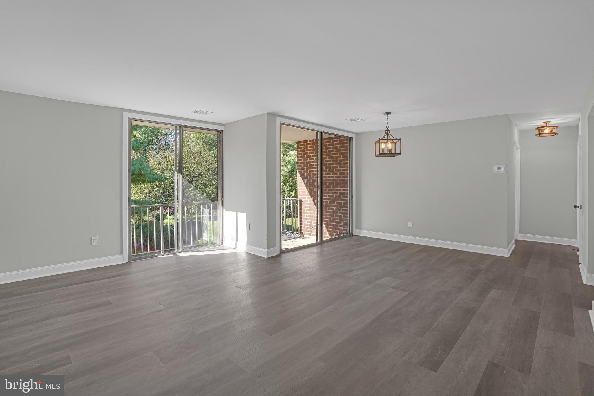 10239 Prince Place, Unit 26103 Upper Marlboro, MD 20774 - Photo 4 of 25 a view of an empty room with wooden floor and a window
