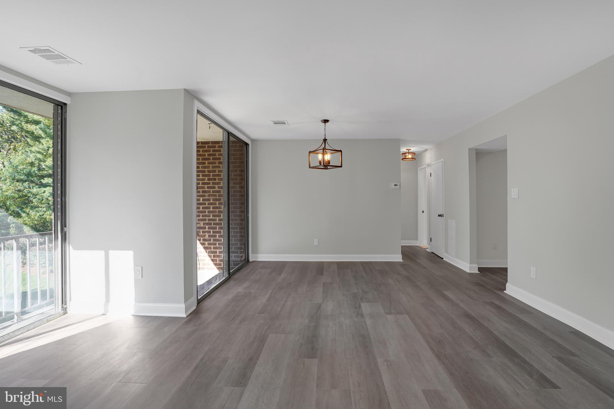 10239 Prince Place, Unit 26103 Upper Marlboro, MD 20774 - Photo 5 of 25 an empty room with wooden floor and windows