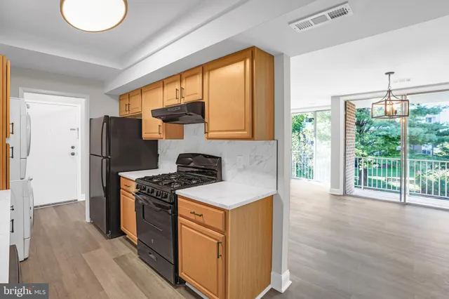 a kitchen with a stove a refrigerator and a wooden floor