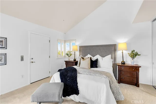 a bedroom with a bed large window and lamp