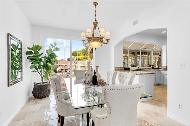 a dining room with furniture a chandelier and a rug