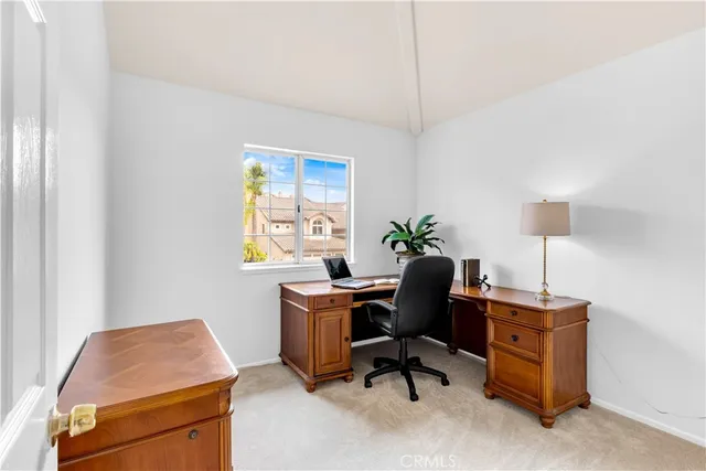 a view of a workspace with furniture and a window