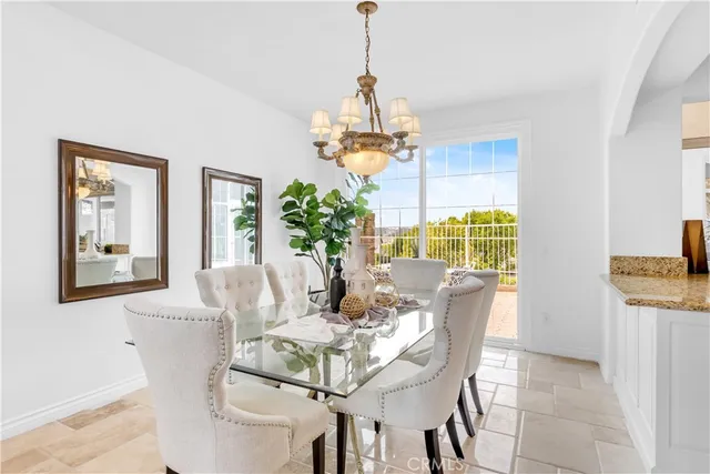 a dining room with furniture a chandelier and window