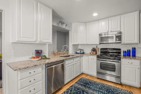 a kitchen with sink cabinets and stainless steel appliances