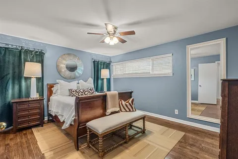 a bedroom with a bed and a mirror on the dresser