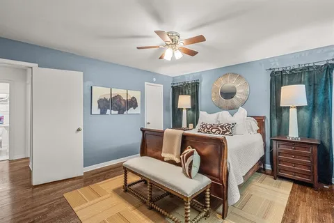 a bedroom with a bed and wooden floor