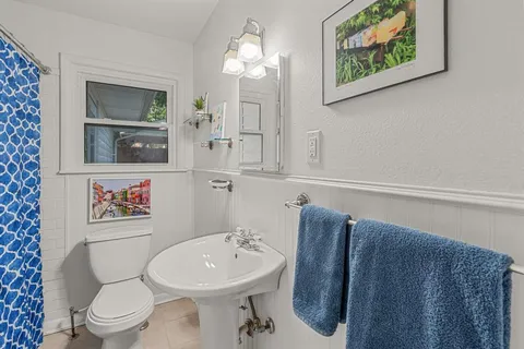 a bathroom with a toilet sink and mirror