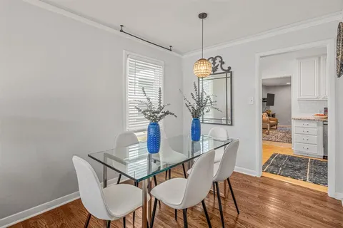 a dining room with furniture a chandelier and wooden floor