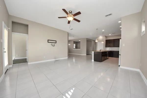 an empty room with windows and ceiling fan
