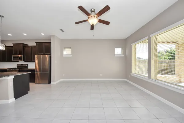 an empty room with window and ceiling fan