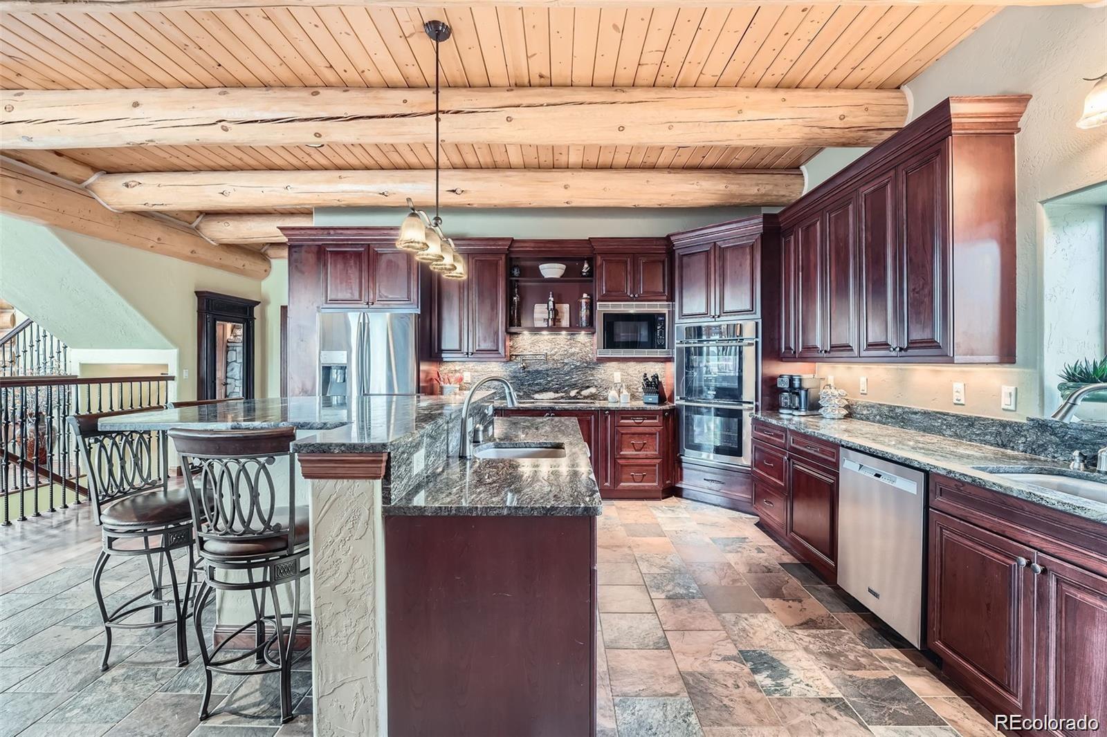 401 Raptor Point Golden, CO 80403 - Photo 7 of 44 a kitchen with granite countertop wooden cabinets a sink and stainless steel appliances