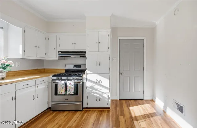 a kitchen with a stove oven and white cabinets