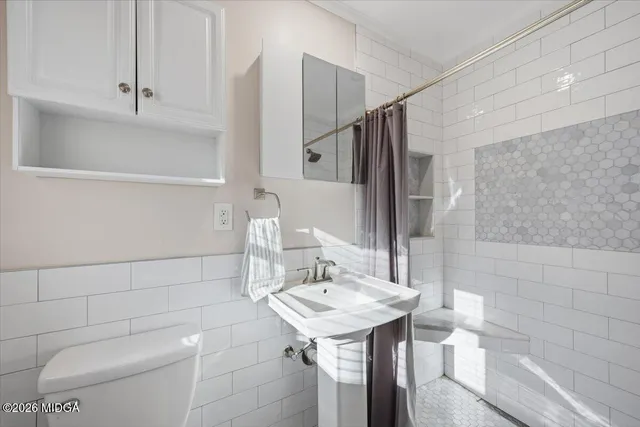 a bathroom with a sink a toilet and shower