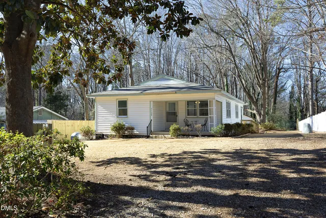 a front view of a house with a yard and trees
