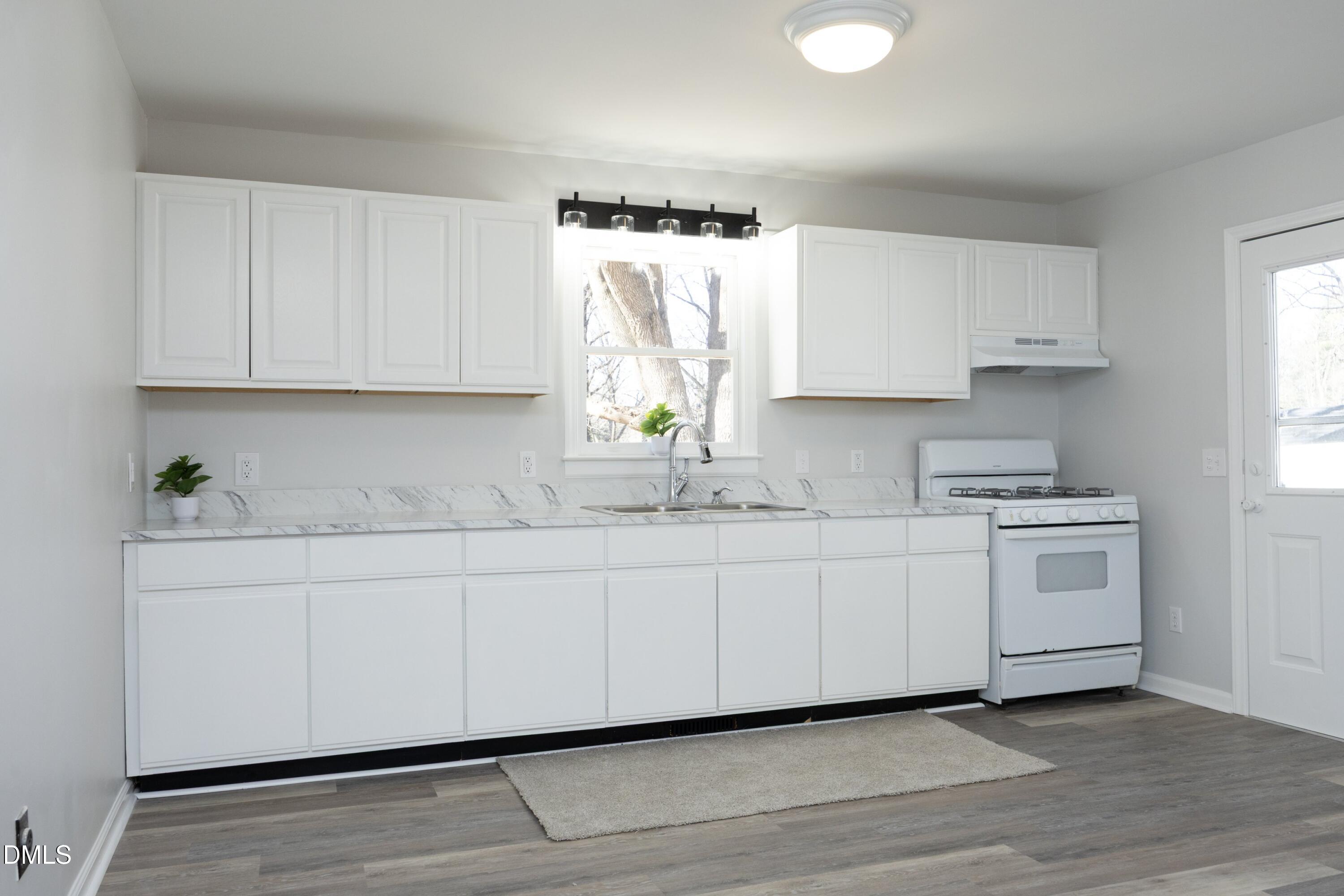 5108 Old Valley Street Raleigh, NC 27603 - Photo 14 of 37 a kitchen with granite countertop white cabinets white appliances a sink and a window