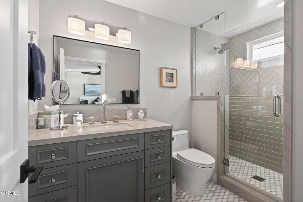 2131 Ravoli Drive Oxnard, CA 93035 - Photo 42 of 53 a bathroom with a toilet a sink a glass door shower and mirror