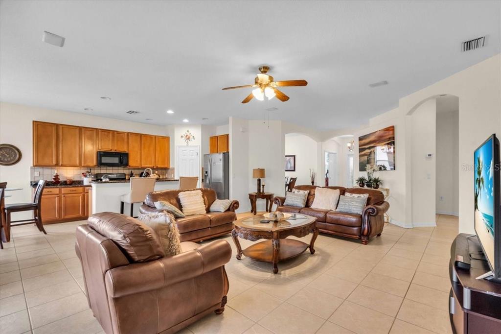 15688 Lemon Fish Drive Lakewood Ranch, FL 34202 - Photo 2 of 18 a living room with furniture kitchen view and a chandelier