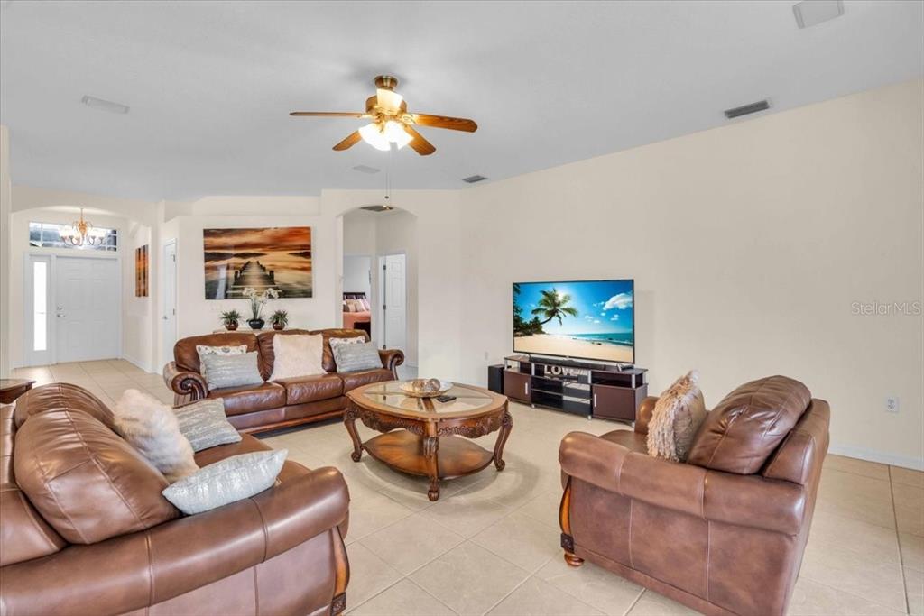 15688 Lemon Fish Drive Lakewood Ranch, FL 34202 - Photo 3 of 18 a living room with furniture and a flat screen tv