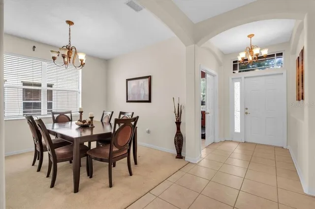 a view of a dining room with furniture and chandelier