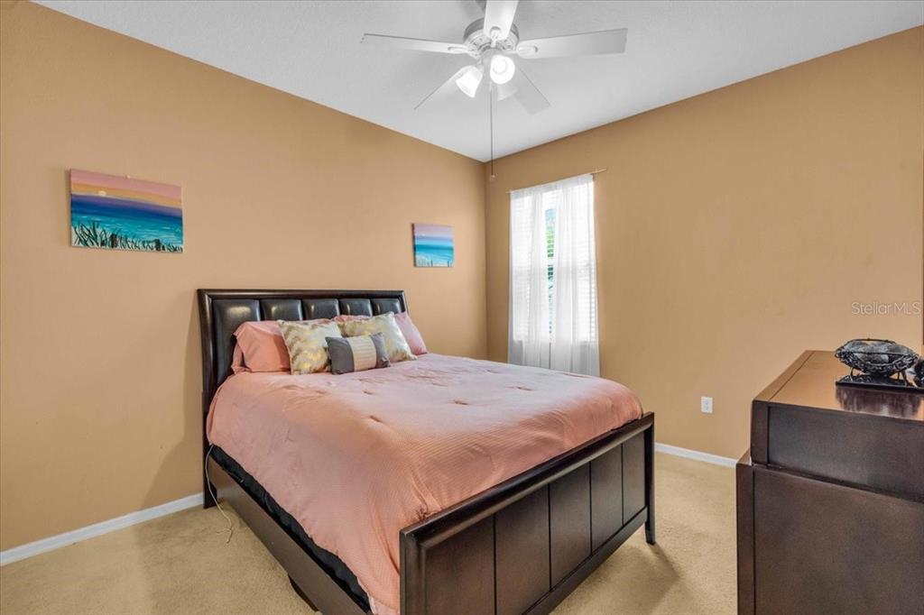 15688 Lemon Fish Drive Lakewood Ranch, FL 34202 - Photo 10 of 18 a bedroom with a bed and a chandelier