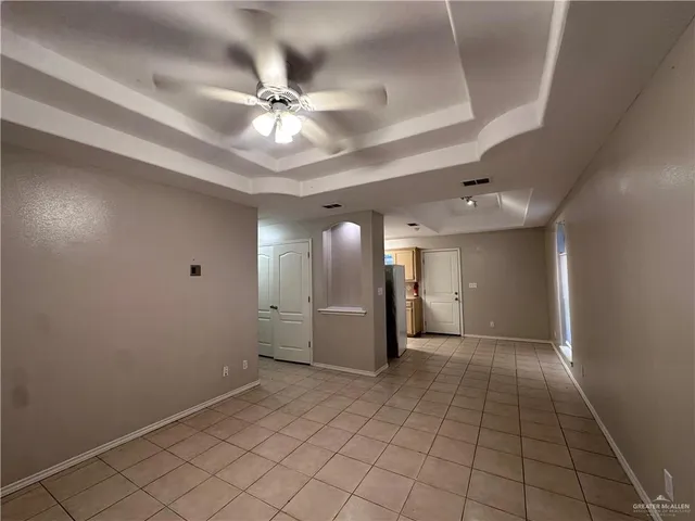 an empty room with a ceiling fan and window