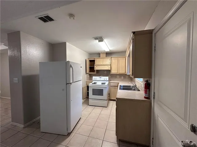 a kitchen with stainless steel appliances granite countertop a refrigerator a stove and a sink