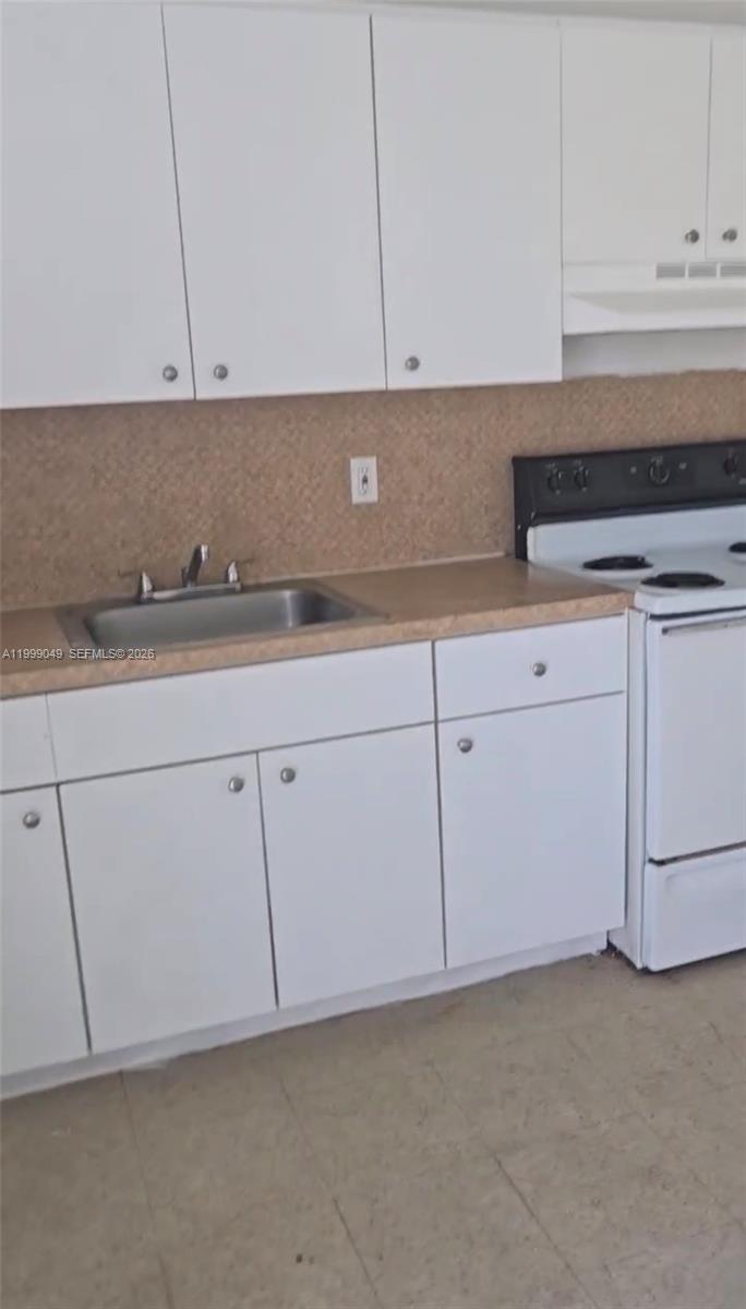 320 Southwest 11th Avenue, Unit 1 Homestead, FL 33030 - Photo 3 of 5 a kitchen with white cabinets and a sink