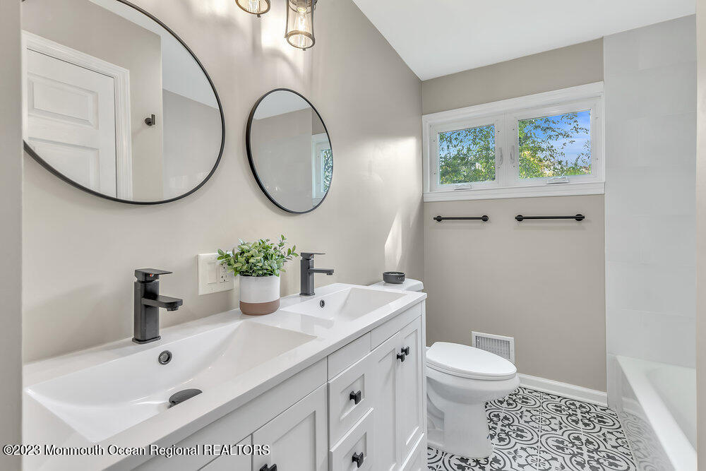 28 Maplecrest Drive Neptune Township, NJ 07753 - Photo 13 of 20 a bathroom with a sink a toilet and a mirror