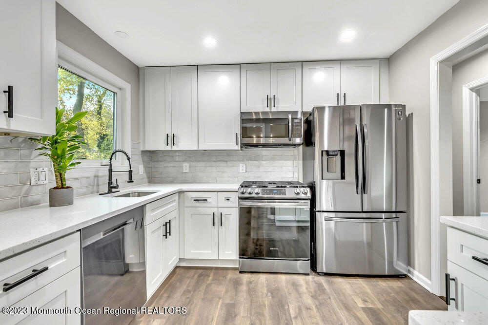 28 Maplecrest Drive Neptune Township, NJ 07753 - Photo 6 of 20 a kitchen with kitchen island granite countertop a sink appliances cabinets and a counter space