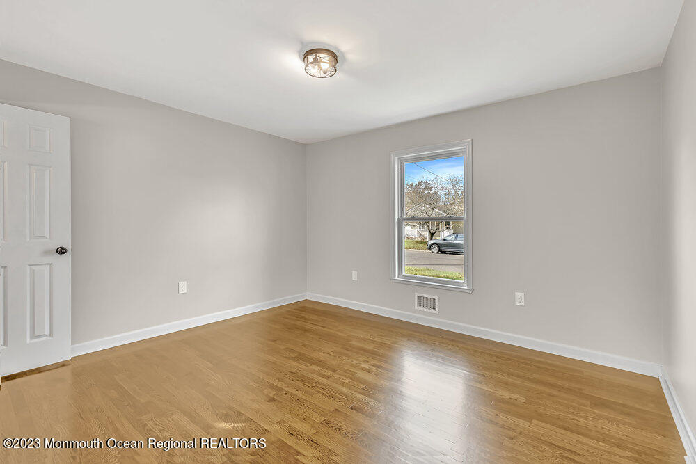 28 Maplecrest Drive Neptune Township, NJ 07753 - Photo 10 of 20 a view of an empty room with wooden floor and a window