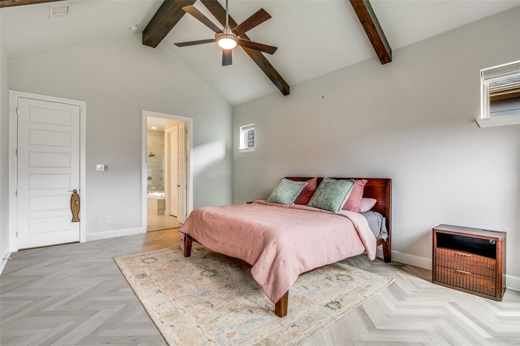 8917 Homestead Boulevard Rowlett, TX 75089 - Photo 18 of 40 a bedroom with a large bed and a chandelier