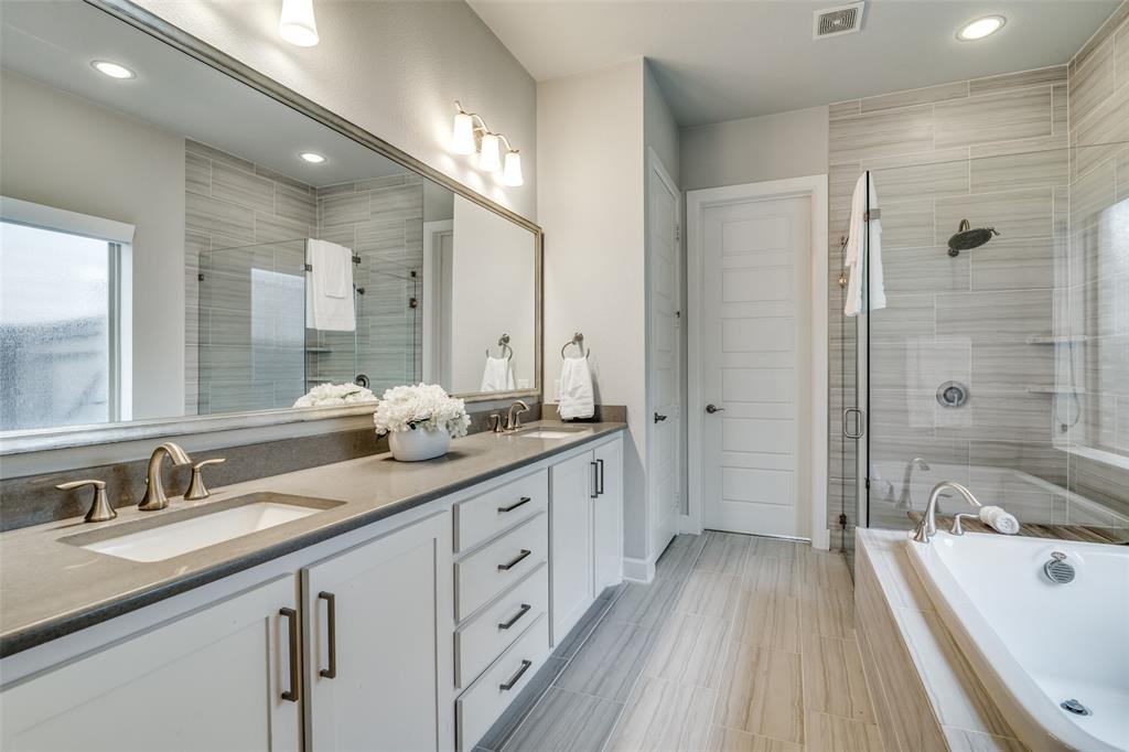 8917 Homestead Boulevard Rowlett, TX 75089 - Photo 19 of 40 a spacious bathroom with a granite countertop double vanity sink a mirror a bathtub and shower