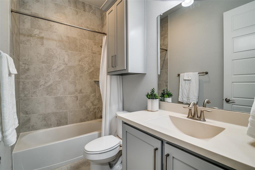 8917 Homestead Boulevard Rowlett, TX 75089 - Photo 23 of 40 a bathroom with a granite countertop sink a toilet and shower