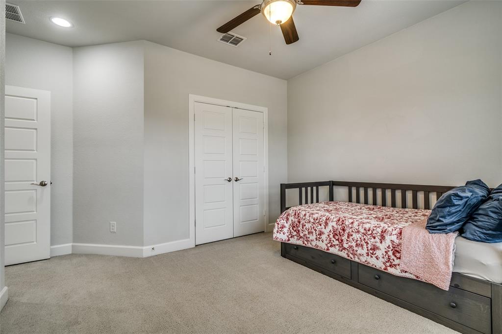 8917 Homestead Boulevard Rowlett, TX 75089 - Photo 29 of 40 a view of a bedroom with a bed and a chandelier