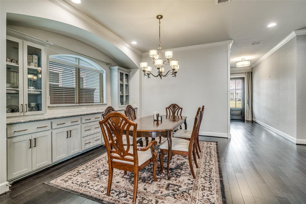 8917 Homestead Boulevard Rowlett, TX 75089 - Photo 8 of 40 a dining room with wooden floor a chandelier a wooden table and chairs