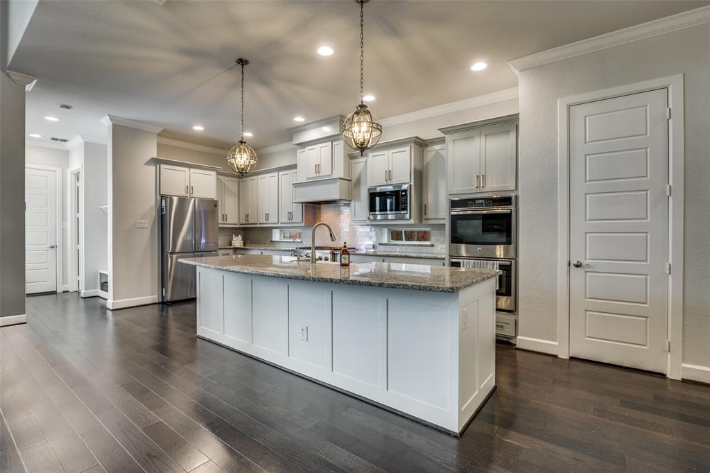 8917 Homestead Boulevard Rowlett, TX 75089 - Photo 9 of 40 a kitchen with stainless steel appliances kitchen island granite countertop a refrigerator a oven and white cabinets with wooden floor