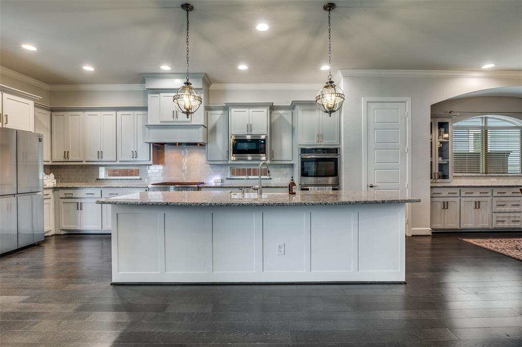8917 Homestead Boulevard Rowlett, TX 75089 - Photo 10 of 40 a kitchen with stainless steel appliances granite countertop a sink a stove and a wooden floors