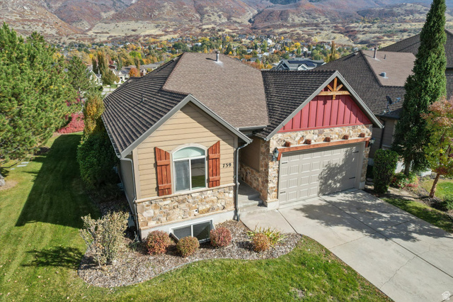 739 South Rice Road Farmington, UT 84025 - Photo 1 of 1 View of front facade with stone siding, concrete driveway, an attached garage, and a mountain view