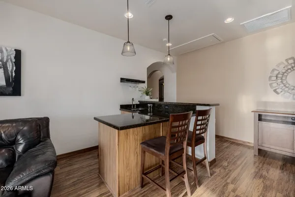 a room with kitchen island a sink a stove cabinets and a window