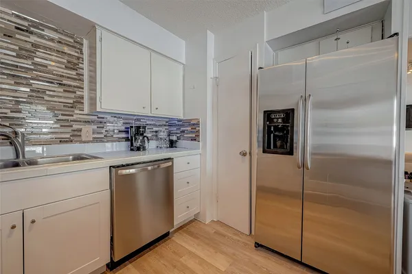 a kitchen with a refrigerator and a sink