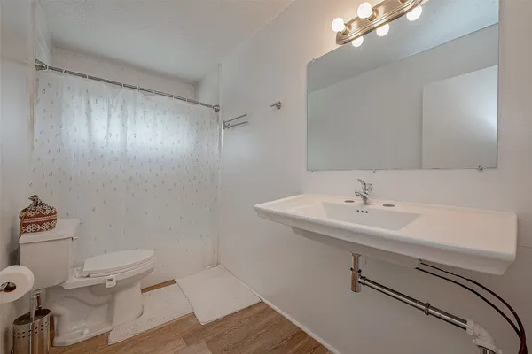 a bathroom with a sink toilet and a mirror