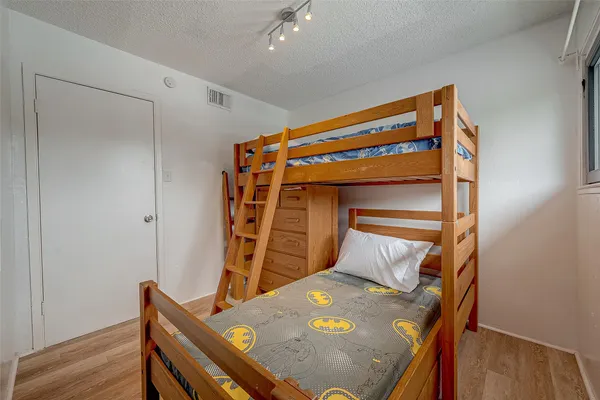 a bedroom with a bed and wooden floor