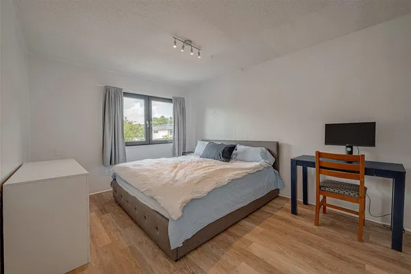 a bedroom with a bed table and a window
