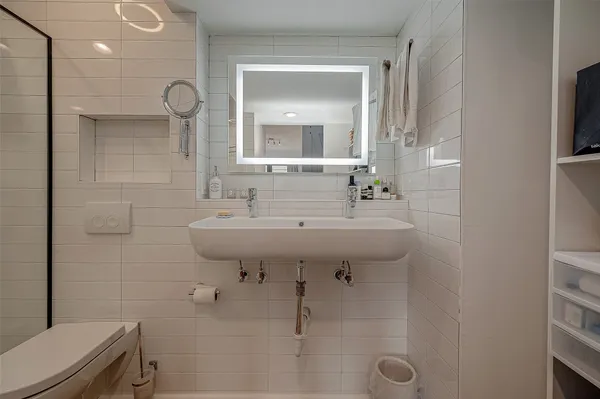 a bathroom with a sink a toilet and a mirror