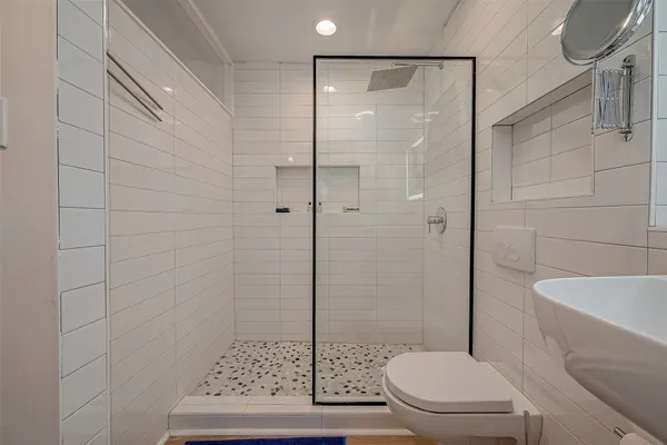 a bathroom with a shower a toilet and a sink