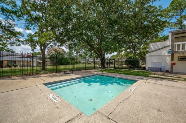 a view of a swimming pool and trees in the background