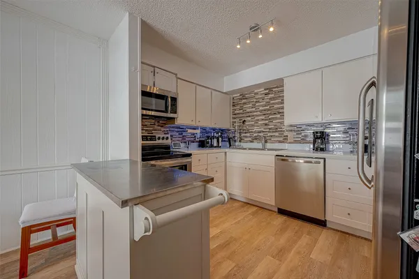 a kitchen with stainless steel appliances granite countertop a refrigerator sink and stove