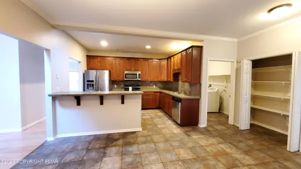 a kitchen with stainless steel appliances a refrigerator and a stove top oven