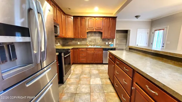 a large kitchen with stainless steel appliances granite countertop a stove and a sink