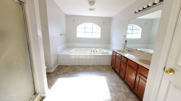 a bathroom with a tub sink and a mirror